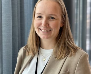 Woman in suit smiling to the camera